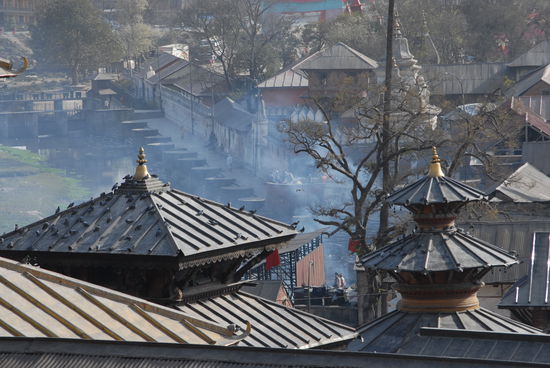 Der Tempelbezirk von Pashupatinath. Der Reuch im Hintergrund ruehrt von den Verbrennungen her.