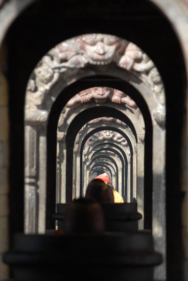Ein Sadhu inmitten von Adligengraebern in der Sonne sitzend