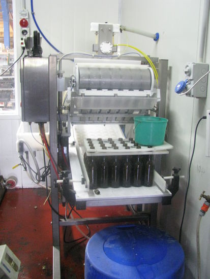 Diese Maschine presst die Deckel auf die Flaschen.