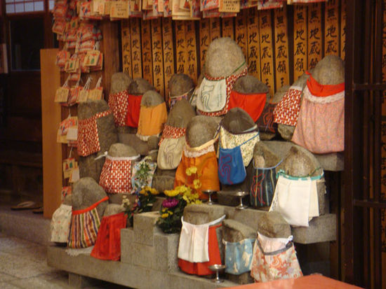 Die Schürzen werden von Eltern oder Müttern, die ihre Kinder verloren haben, angebracht. Reist man durch Japan sieht man enorm viele dieser Figuren und wundert sich, ob wirklich so viele Kinder gestorben sind. Was in der Regel verschwiegen wird ist, dass auch an ungeborene Kinder, die durch eine Abtreibung nie das Licht der Welr erblickt haben, gedacht wird. Die Zahl der Abtreibungen war früher wohl sehr hoch, da die Frauen keine Pille genommen haben.