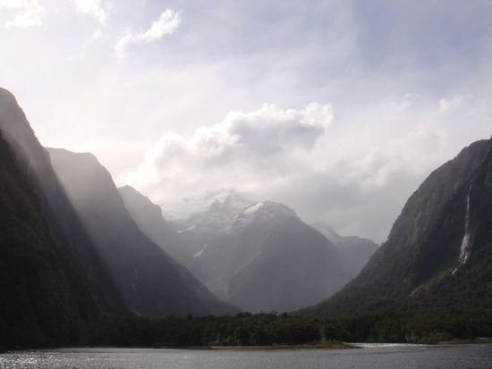 Blick vom Boot auf die schneebedeckten Gipfel im Hintergrund