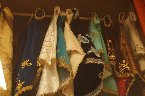 hier sieht man Taufkleider in einer Vitrine hängen