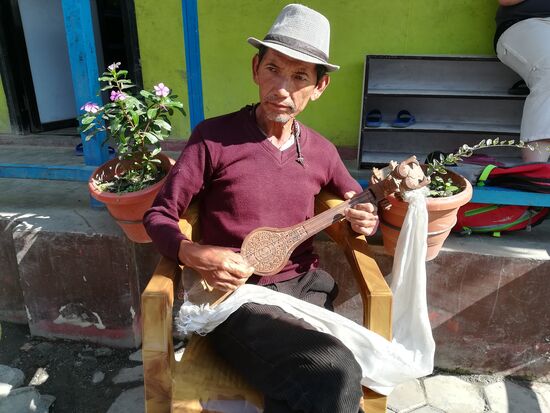 Der Vater von Kinga. Er spielt ein altes Instrument. Die Kunst es zu spielen wird von Generation zu Generation weitergegeben.