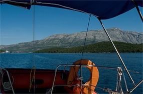 Blick zurück: Verlassen der Insel Korcula mit Kurs Südost in Richtung der Insel Mljet. Rechts die kleine Insel Badija (unmittelbar östlich der Insel Korcula). Im Hintergrund die mächtigen Erhebungen der Halbinsel Peljesac