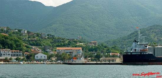 Anfahrt auf den Einklarierungshafen Zelenika. Das orange-gelbe Willkommensschild gibt die Stelle fü die Ein-/Ausklarierung an. Das kleine Kirchlein im Zentrum des Fotos (über dem Willkommensschild) kann vom Meer komend gut als Ansteuerungspunkt benutzt werden.