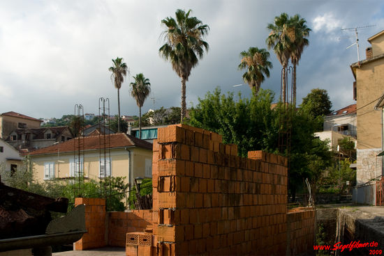 Viele unfertige Häuser, deren Baubeginn offensichtlich bereits längere Zeit zurückliegt, stehen ungeniert Seite an Seite mit ...