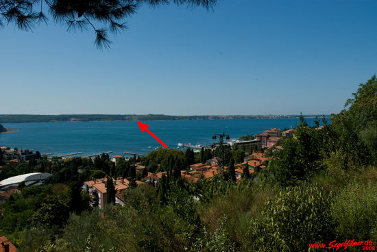 Die Bucht von Piran: Wiedersehen mit der Stelle, an welcher der Blitz unseren Segeltörn vorzeitig beendete. Nur diesmal von slowenischer Seite aus gesehen. Die Stelle ist mit einem Pfeil markiert und die gesamte Bucht macht heute einen so harmlosen Eindruck.