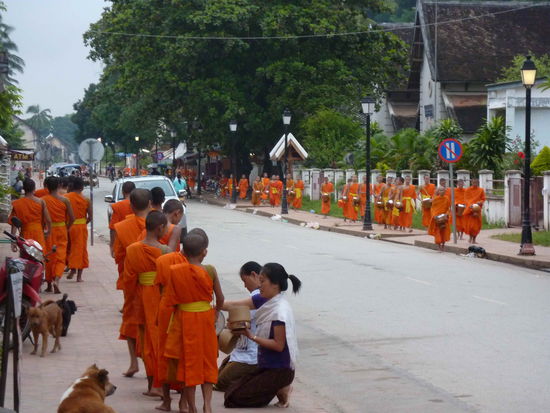 dag bat... der allmorgendliche Gang der Moenche. Die Glaeubigen schenken ihnen Essen fuer den Tag, eine Methode fuer einen Buddhisten ein Verdienst zu erwerben.