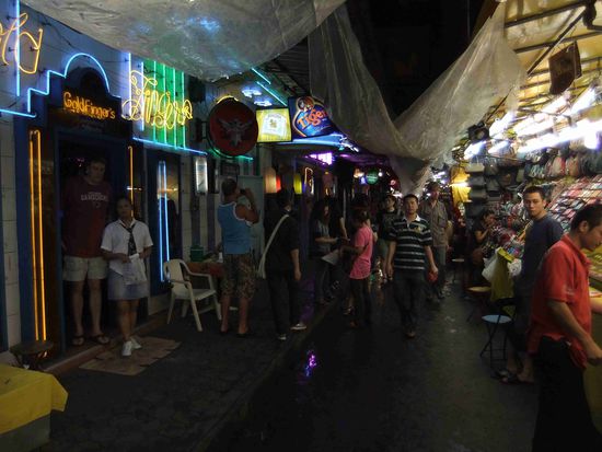 Patpong , Nachtmarkt (rechte Bildseite) für Touristen und Vergnügungsviertel für Sextouristen mit vielen Bars und Clubs (linke Bildseite).