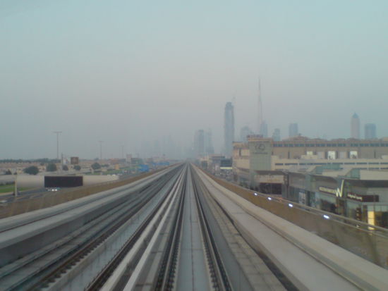 Fahrerlos: Die Metro in Dubai. In einigen Kilometern Entfernung zeichnet  sich im Dunst der Stadt die Skyline der Downtown ab.