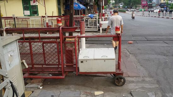 ..........fahren diese Schranken über die Straße. Nicht selten schummeln sich dann - die Straße ist nicht immer so leer wie hier gerade - noch zahlreiche Roller durch den immer enger werdenden Platz. Dabei kann man auch mal auf die Gegenfahrbahn ausweichen.