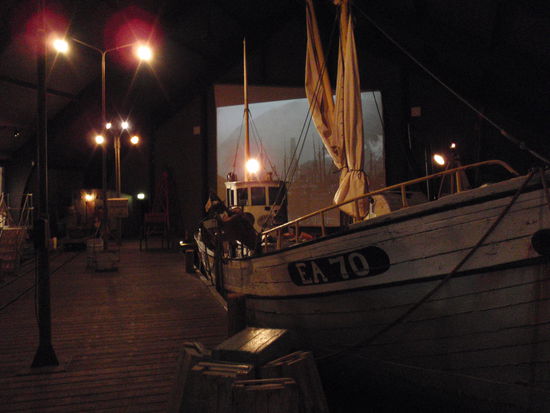 Nachstellung des Hafens von  Siglufjördur an einem Winterabend, in der dunkeln nur mit Laternen beleuchteten Halle des Heringsmuseums