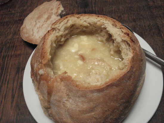 Knoblauchsuppe im Brotlaib serviert