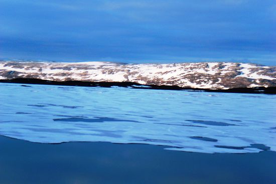 Irgendwo hinter diesen Bergen verläuft die norwegische Grenze - eine imaginäre Linie zwischen Steinen, Schneefeldern, Seen und Zwergbirkensträuchern in der fast unendlichen Weite.