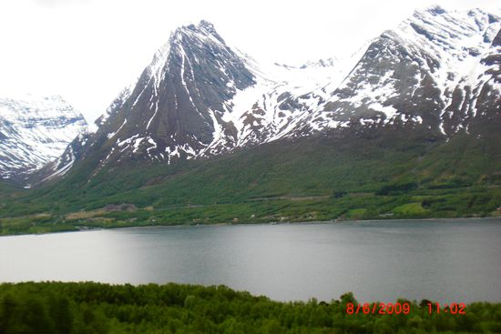 Nein, das sind keine schneebedeckten Dreitausender in der Schweiz - diese Berge haben nur eine Höhe von wenigen hundert Metern. Der "See" ist jedoch ein Fjord und liegt natürlich auf Meeresspiegelhöhe.