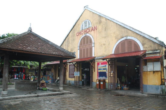 Die Markthalle von der unbelebten Seite aus, vorne ein Brunnen
