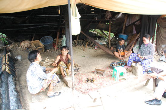 Links am Bildrand die Bambusrohre mit dem Reis auf den Kohlen