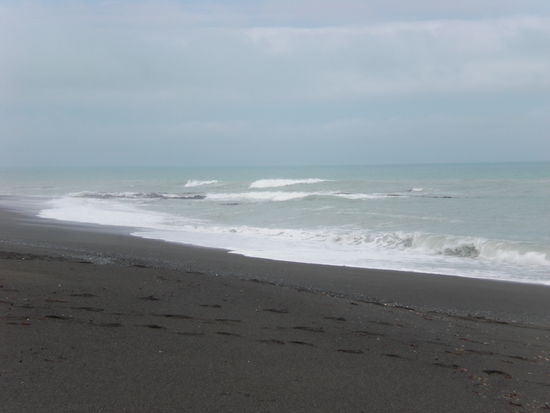 dunkler Sand + hellblaues Wasser