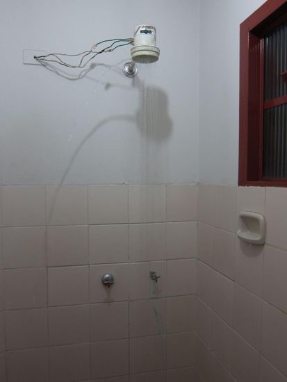 Duschkopf des Grauens. Da es hier oft kein Warmwasser gibt, gibt es beheizte Duschköpfe. Man(n) beachte die liebevolle Verkabelung und wenn man ganz genau schaut sieht man (vor allem im Schatten) das der Duschkopf nicht nur nach unten Wasser abgibt sondern auch zur Seite raus. Sehr vertrauenserweckend !
