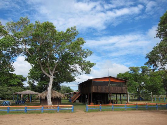 Der Campingplatz: im unteren Teil des Gebäudes wurde gekocht, gegessen und gemütlich beisammen gesessen. Im oberen Teil der "Schlafsaal" mit den Hängematten. Links vom "Haupthaus" (direkt hinter dem Baum war die Bar. Riiiiiesigst sozusagen...