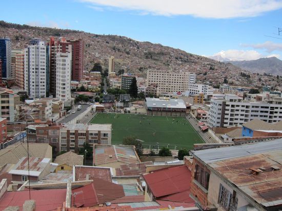 Kunstrasenplatz mitten in der Stadt. Wer genau schaut sieht das rege Treiben am Platz.