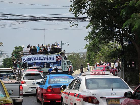 So sieht eine Demo in Thailand aus. Wir konnten das bunte Treiben mit Trompeten und Trillerpfeifen eine Zeit lang beobachten und auf uns machte das Geschehen eher den Eindruck einer großen Party, als nach gewaltbereiten Hooligans.