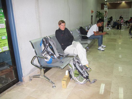 Am Flughafen mussten wir uns warm anziehen, da die Klima mal wieder auf gefühlte Antarktistemperatur heruntergedreht war.
Am Boden sieht man die Holzkiste mit besagtem Holzhai.