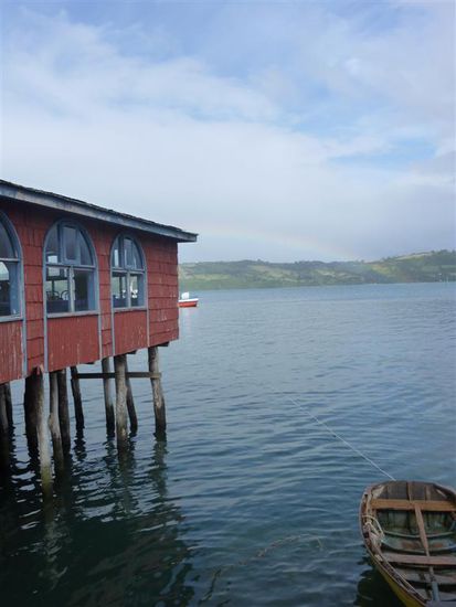 Im Hintergrund sieht man einen Regenbogen 