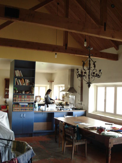 blick aus der kamelbehausten lounge ueber den tollen kuechentisch in die kueche hinein. cesar kocht was. es wird vielleicht der vegane schoko-kuchen!