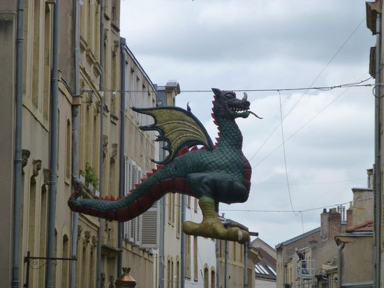 Keine Reklame für ein China-Restaurant, sondern Graoully. Der Drache hauste der Legende nach in den Ruinen des römischen Amphitheaters der Stadt Metz, bis ihn der heilige Clemens, erster Bischof von Metz, im 3. Jahrhundert vertrieb.