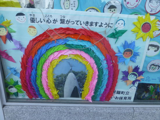 Bunte Papier-Kraniche, gefaltet von Schulkindern aus aller Welt, umrahmen das Mahnmal