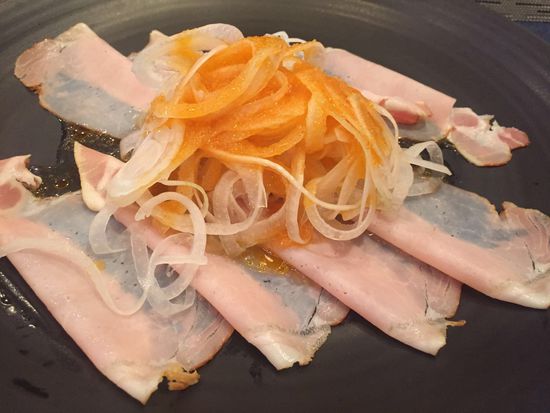 Eine Vorspeisenplatte mit Schinken und gehobelten, milden und mit irgend etwas eingelegten Zwiebeln