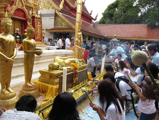 Buddhisten beim Beten. Blume und Raeucherstaebchen sind immer dabei
