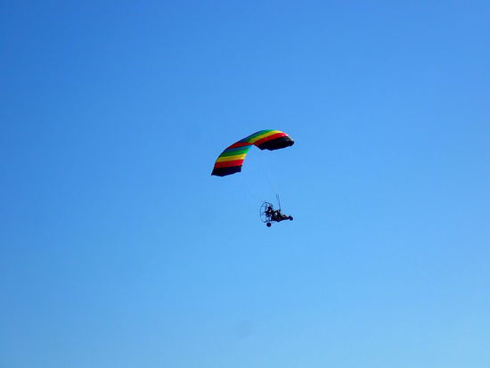 Über uns ein Paragleiter mit Motor