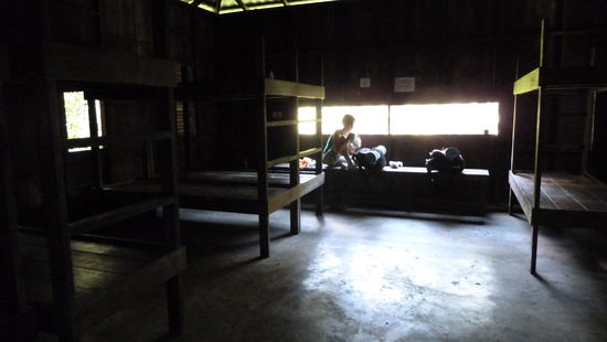 Der Hochstand von innen. Vier Etagenbetten - bzw. zumindest die Holzgestelle - und eine Bank vor dem Guckloch 