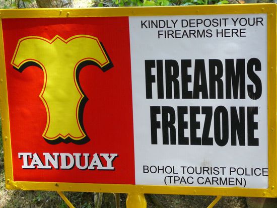 krasses Schild! man wird gebeten, dass man hier seine Schusswaffe abgibt...