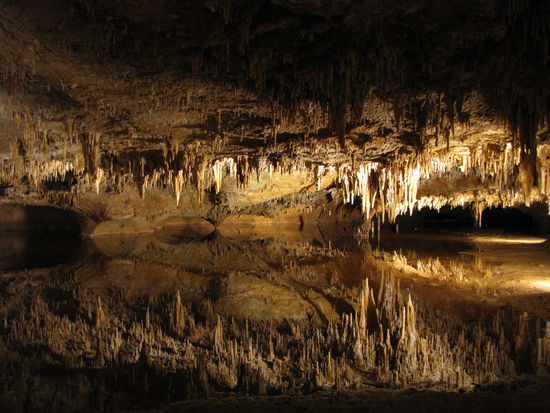 Im unteren Teil des Fotos spiegeln sich die Stalagtiten im Wasser.
