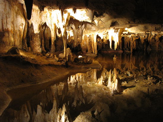 Im unteren Teil des Fotos spiegeln sich die Stalagtiten im Wasser.