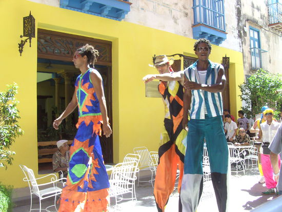 Tanzende Menschen auf rieseigen Stelzen