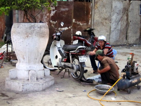 Ein Land mit vielen Rollern braucht auch viele Mechaniker... Typische Strassenszene in jeder vietnamesischer Stadt