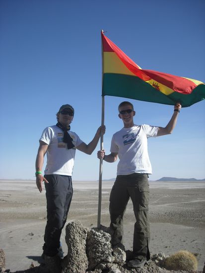 Vor einem Hoehleneingang mit Sven unter der Fahne Boliviens.