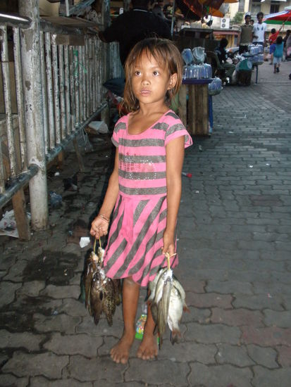 Ein Mädchen auf dem Markt das Fische verkauft