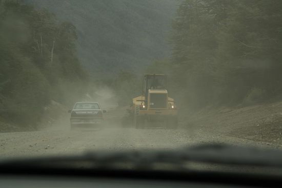 Die Steine auf der Strasse werden unter Einsatz schwerer Technik zur Seite geschoben.