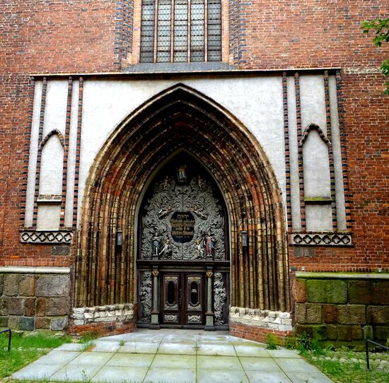 Blick aus der Passage auf ein Tor in der Nikolaikirche nebenan