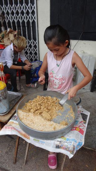Das Mädchen hat die ganze Zeit das harte Karamell zerschlagen. In kleine Tüten abgefüllt wird es verkauft