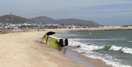 Ein unsanft angespülter Kitesurfer am weißen langen Sandstrand