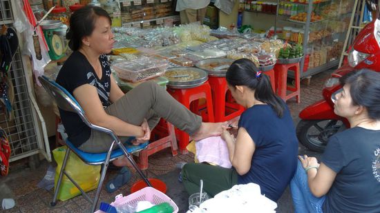 Hier wird einiges auf der Straße erledigt, so auch diese Pediküre, direkt vor den "süßen" Auslagen