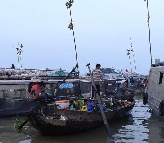 An den langen Stangen sind Warenmuster angebunden, damit man schon von weitem sieht, wo es das gesuchte Obst oder Gemüse gibt