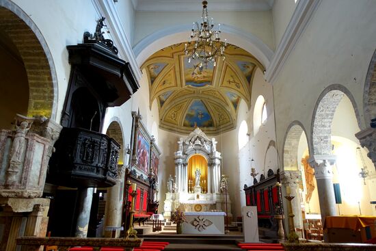 Innen der Marmoraltar mit einer barocken Holzkanzel. An den Wänden Gemälde ital. Meister
