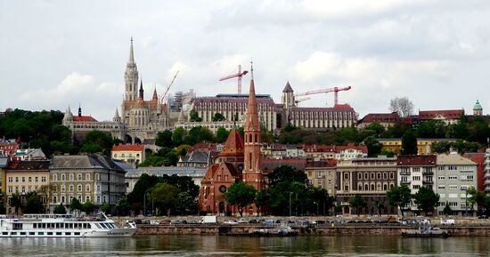 Fast genau gegenüber vom Parlament die rote reformierte Kirche am Dezsö Platz, direkt an der Donau, im Hintergrund Fischerbastei und die Matthiaskirche